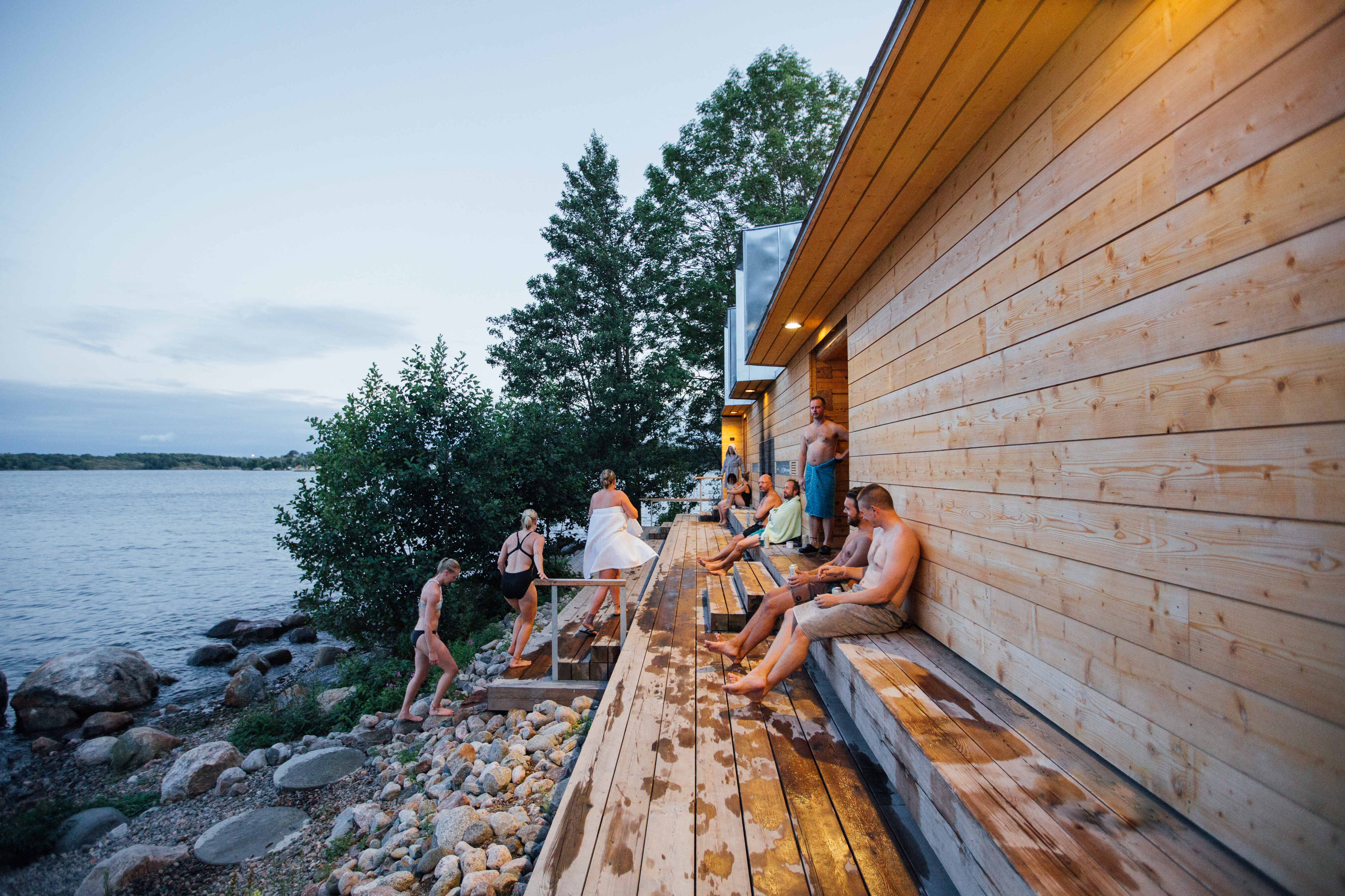 Terraza de una sauna llena de gente junto al mar Báltico en la isla de Lonna