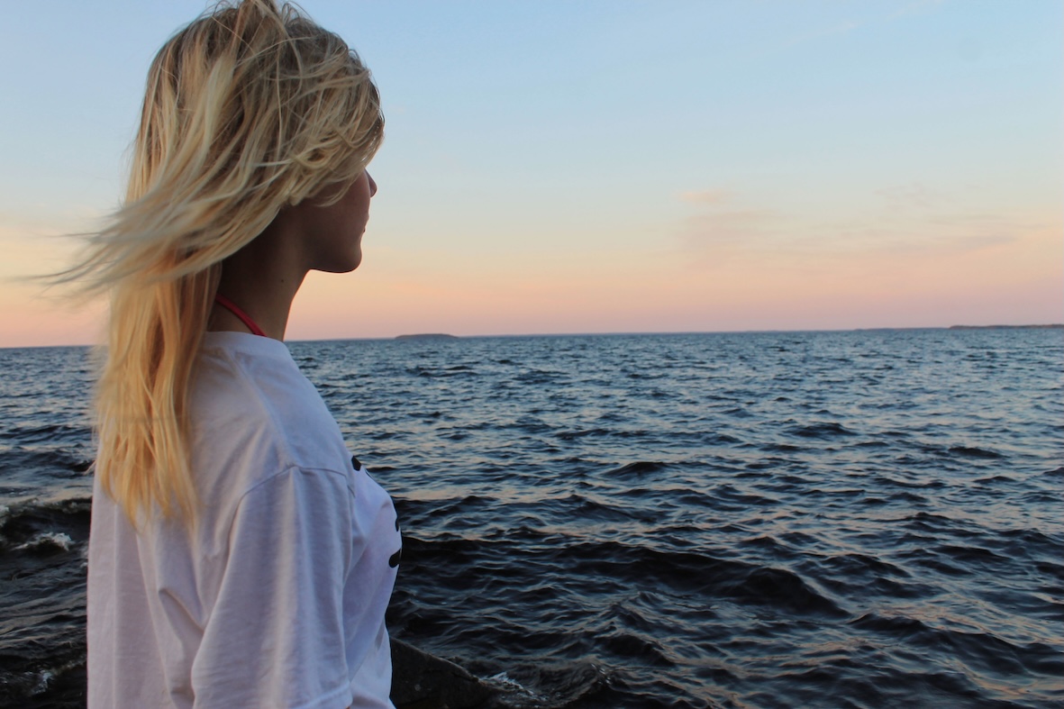 A woman staring at the lake Oulujärvi in Finland.