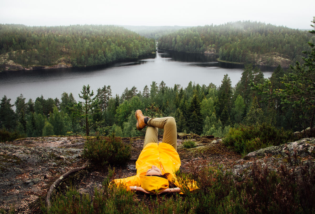A person is lying down in front of a Lake landscape in Finland.