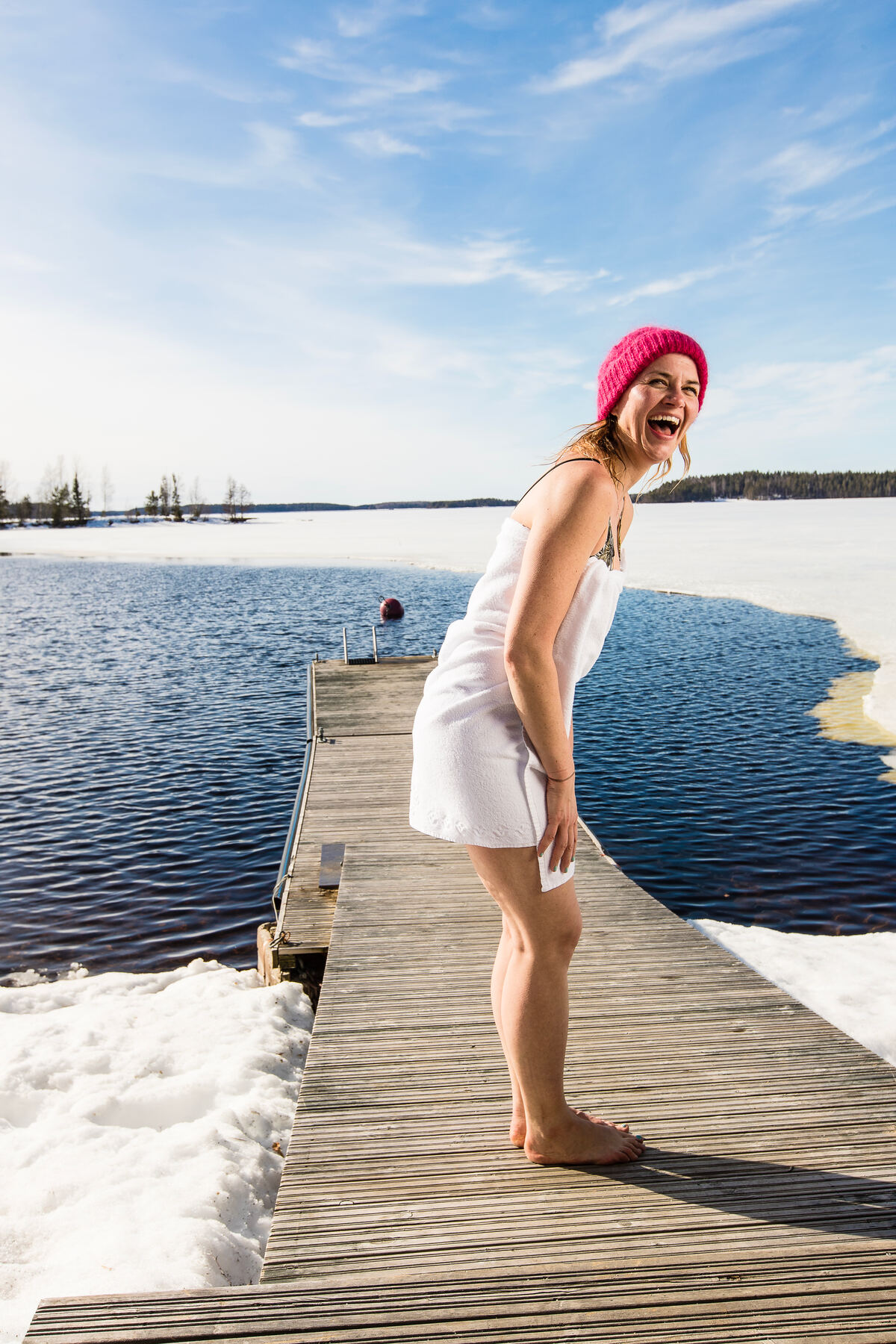 An excited woman about to go winter swimming