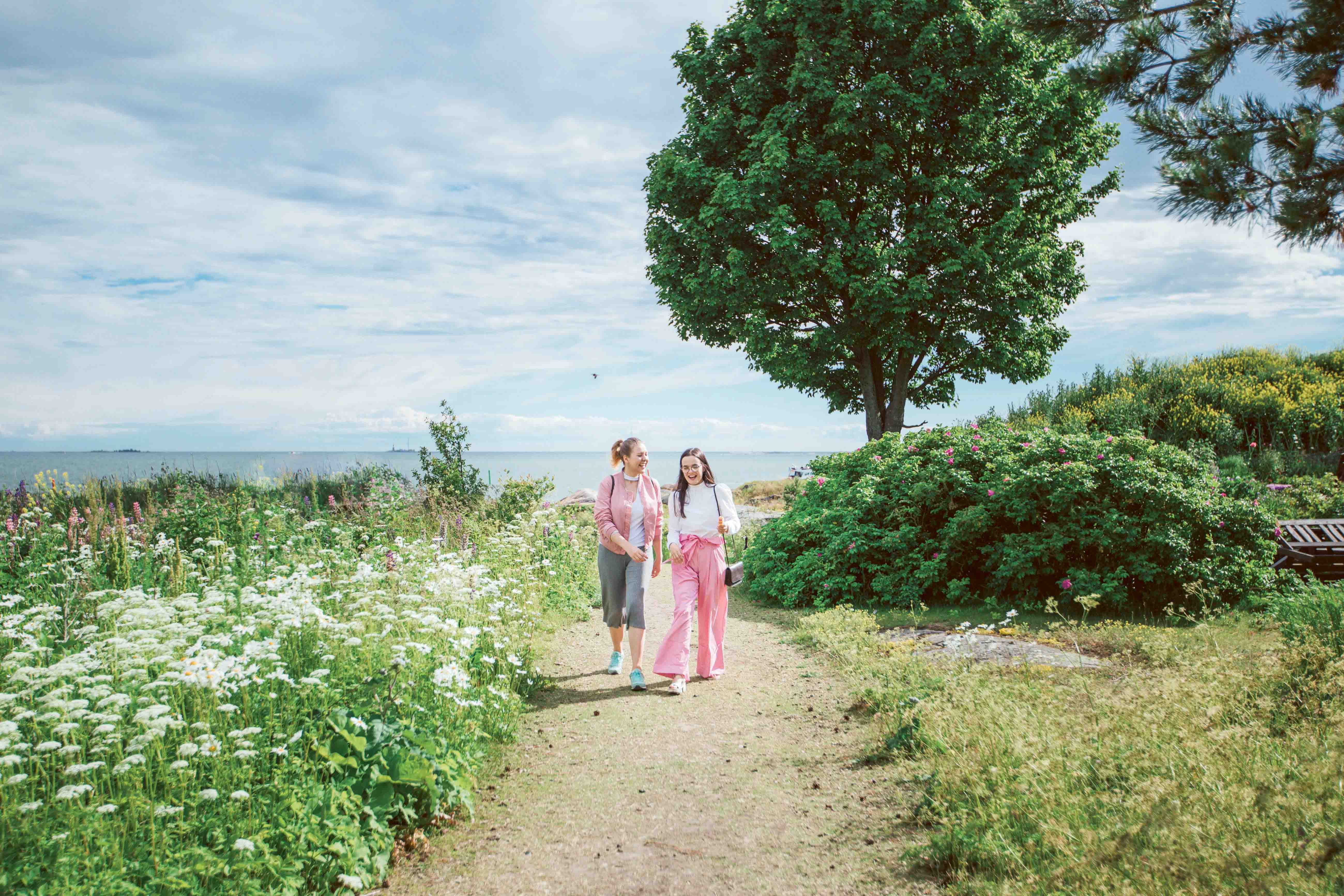 Two young women walking in nature at Suomenlinna fortress