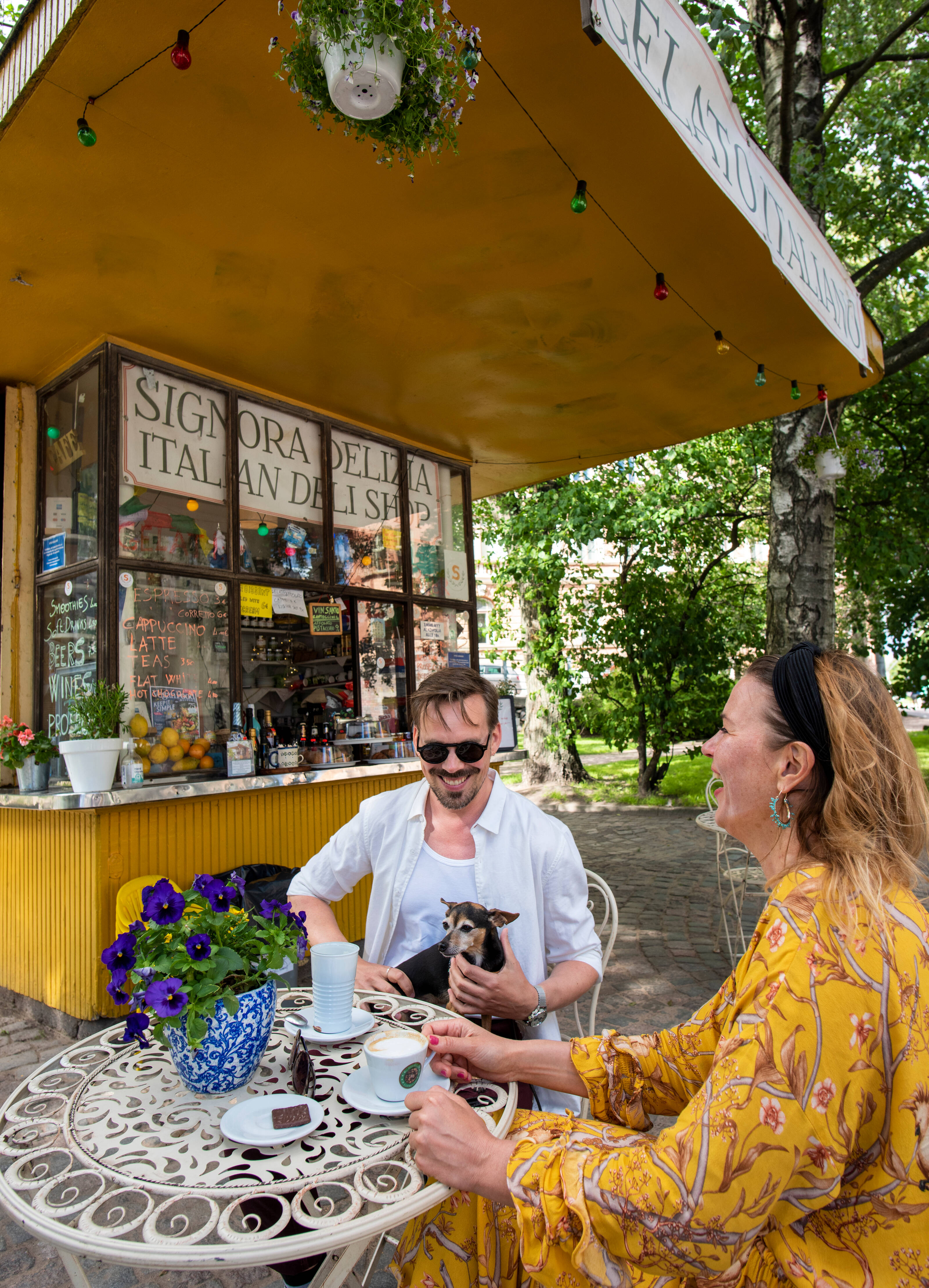 Laughing people drinking coffee on a terrace in the Helsinki archipelago