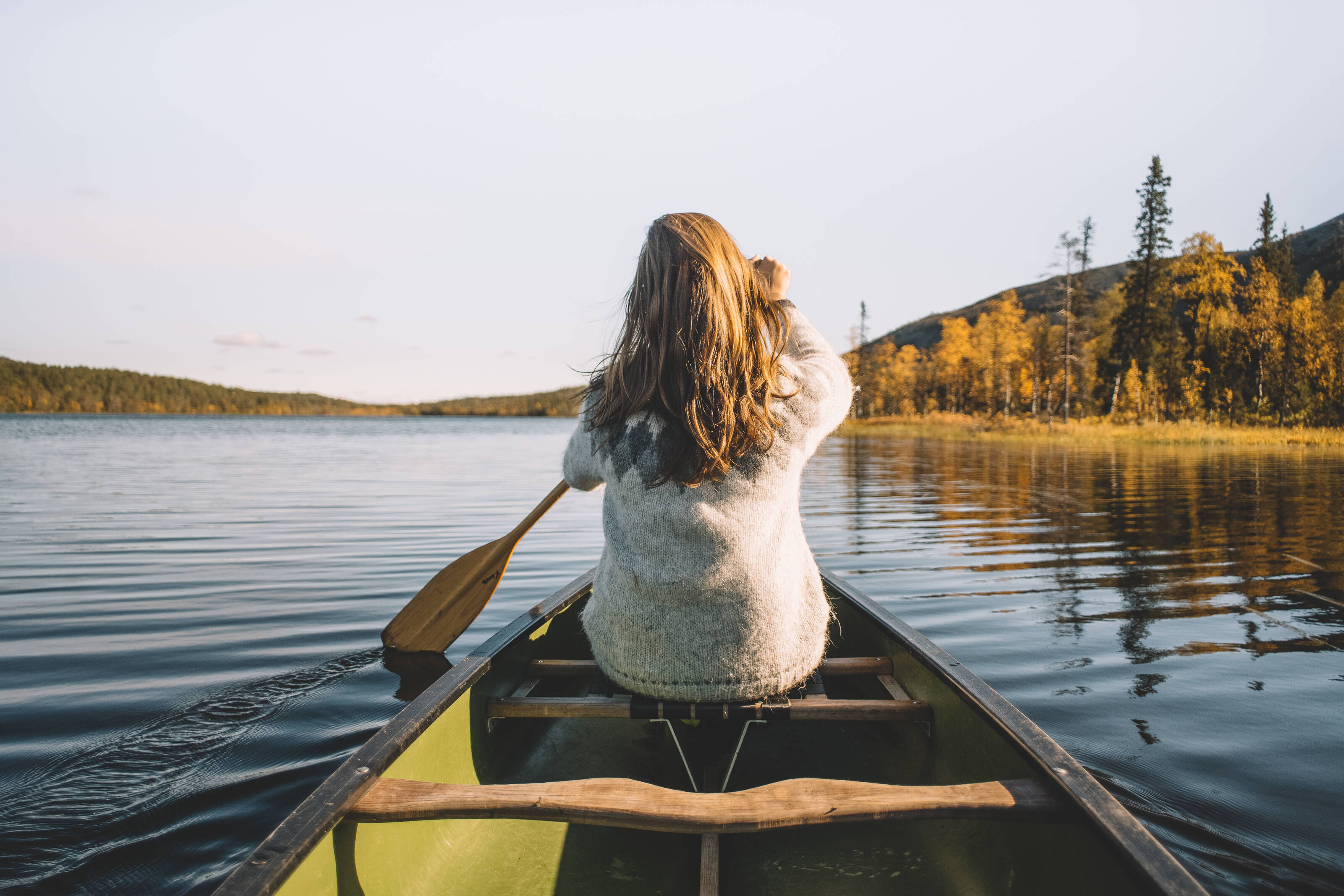 Женщина гребет на фоне озера в Финляндии