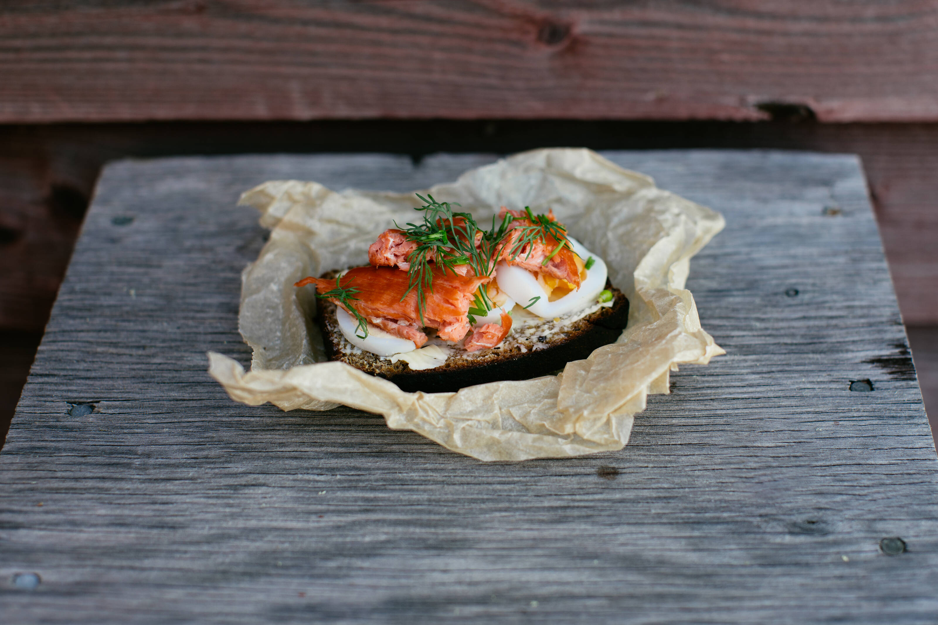 A slice of Finnish saaristolaisleipä served with egg and salmon.