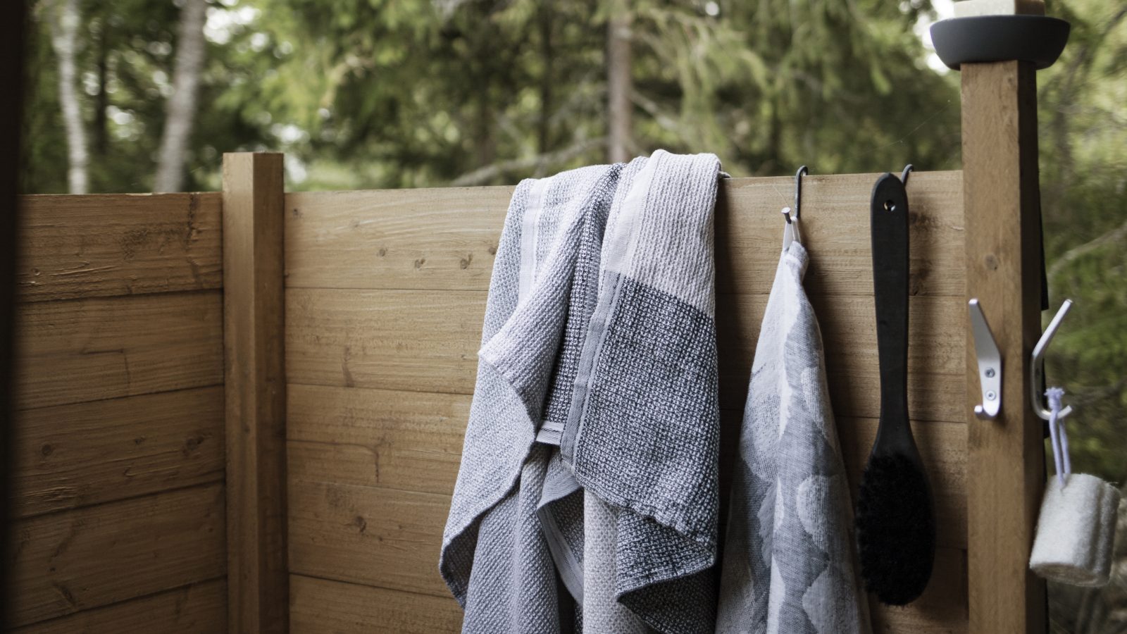 towels and other accessories hanging on a wall in an alfresco shower  