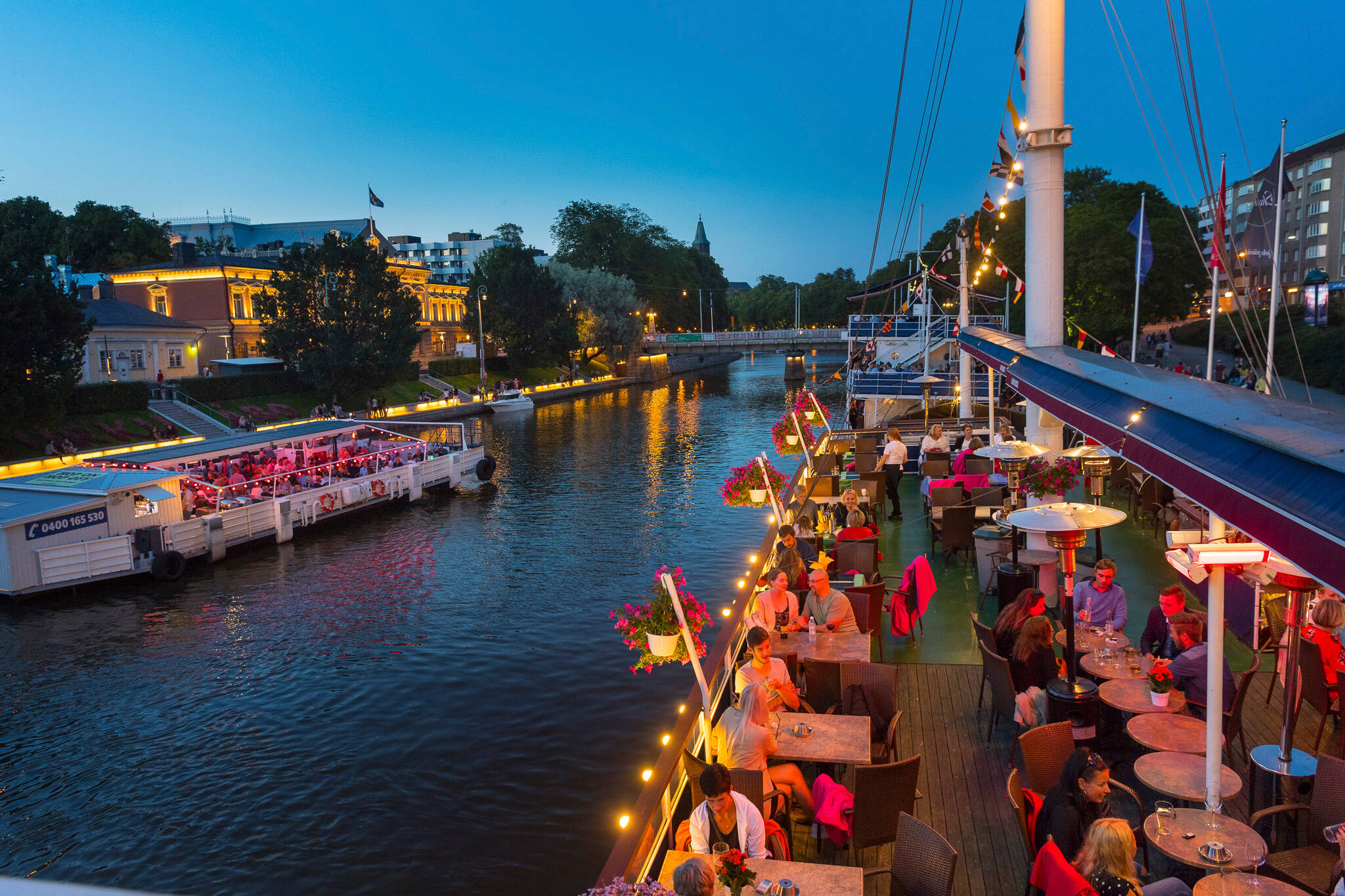 Personen auf einem Restaurantschiff auf dem Fluss Aurajoki in Turku