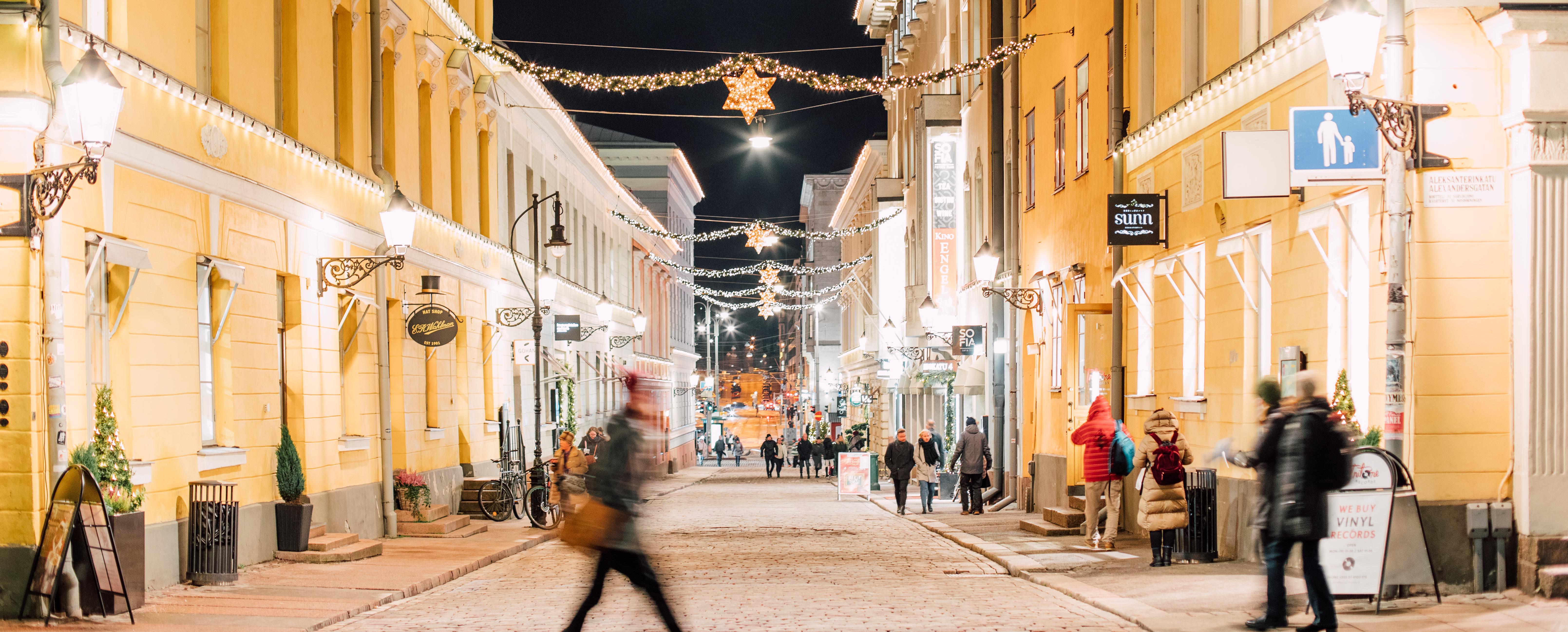 Une rue pleine de lumières de Noël et de gens dans le centre-ville d'Helsinki la nuit