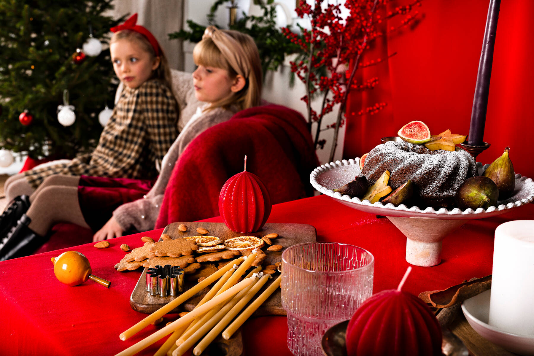 children on a couch and Christmas treats and delicacies on a table
