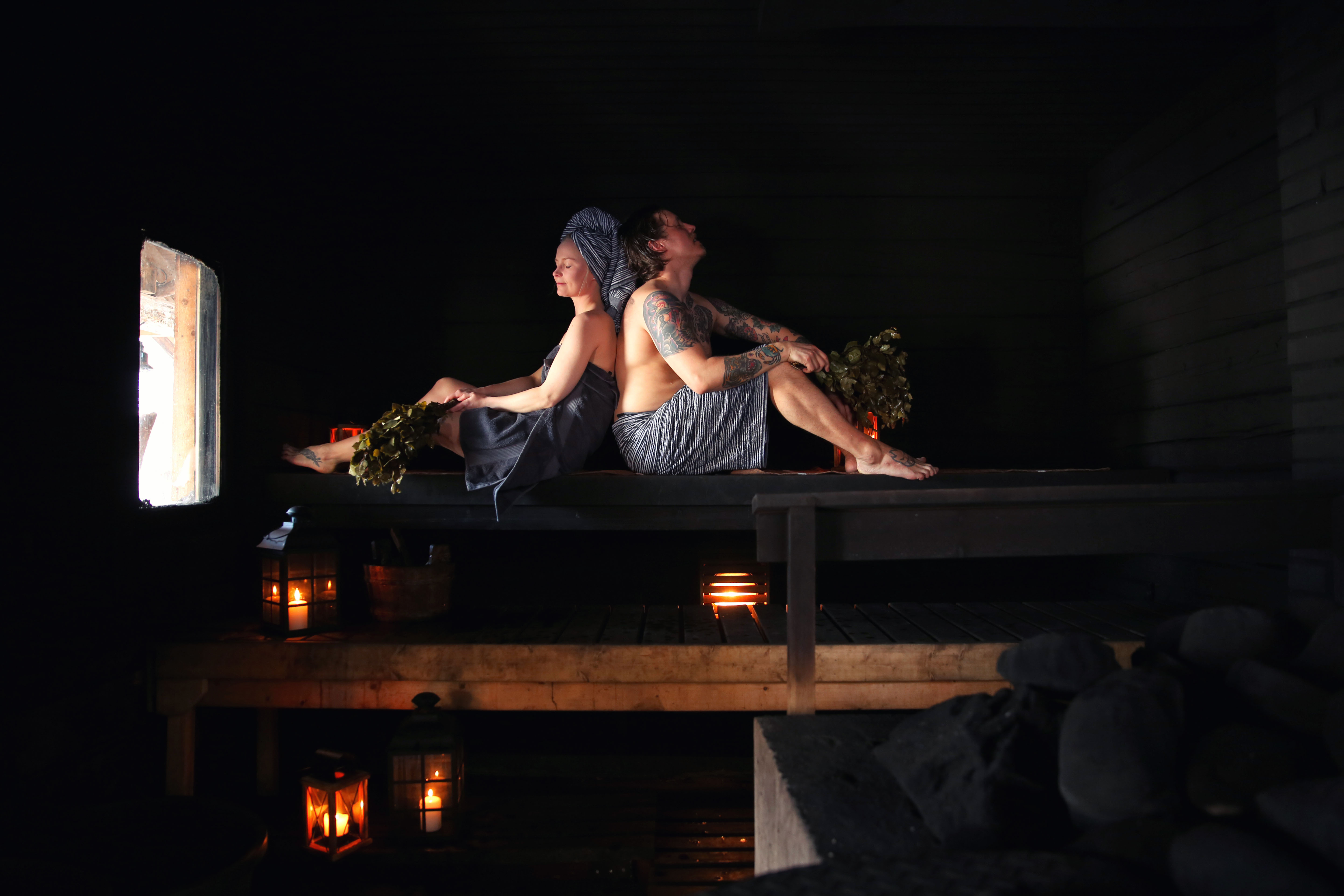 A couple in sauna relaxing back to back