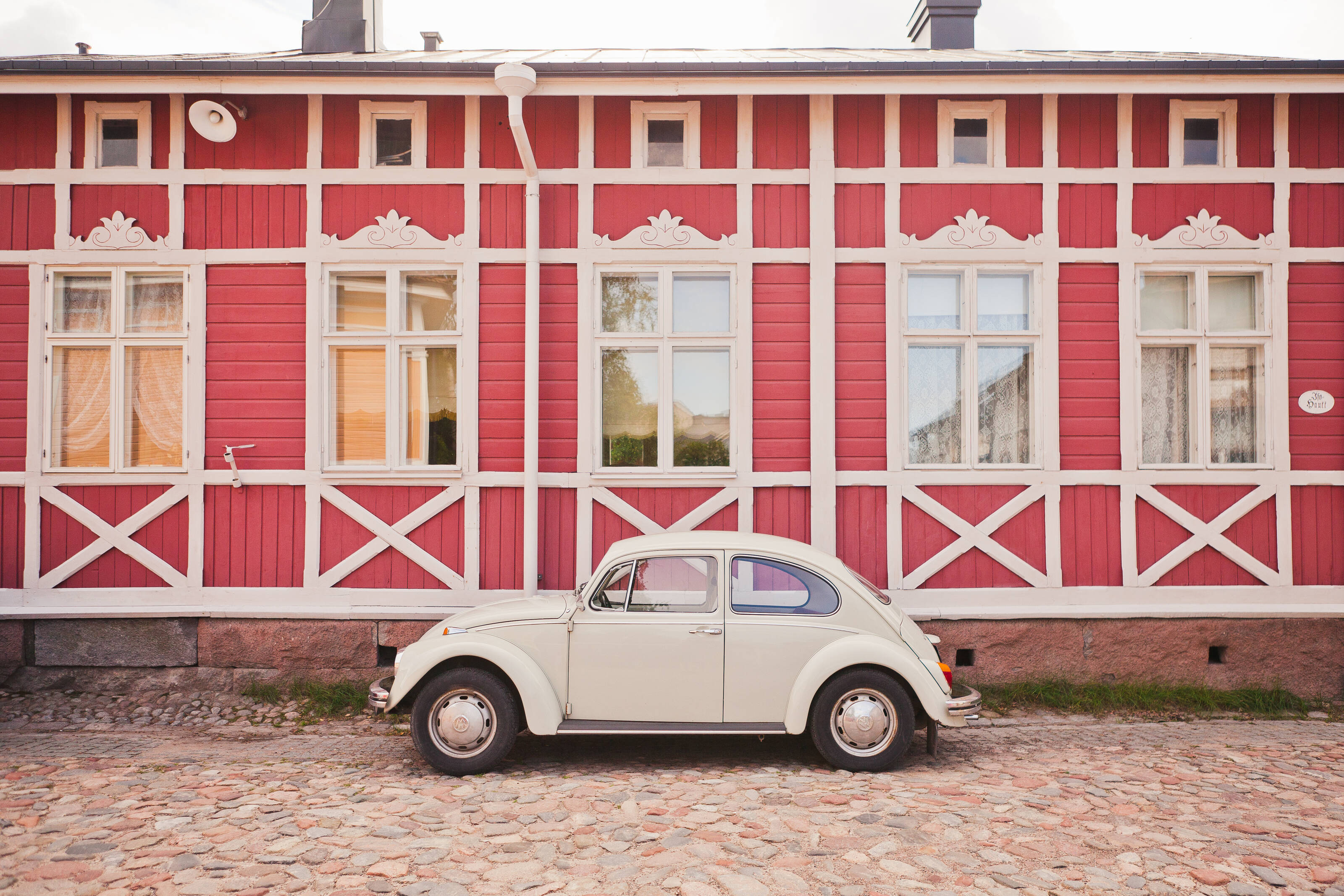 старая машина перед розовым деревянным домом