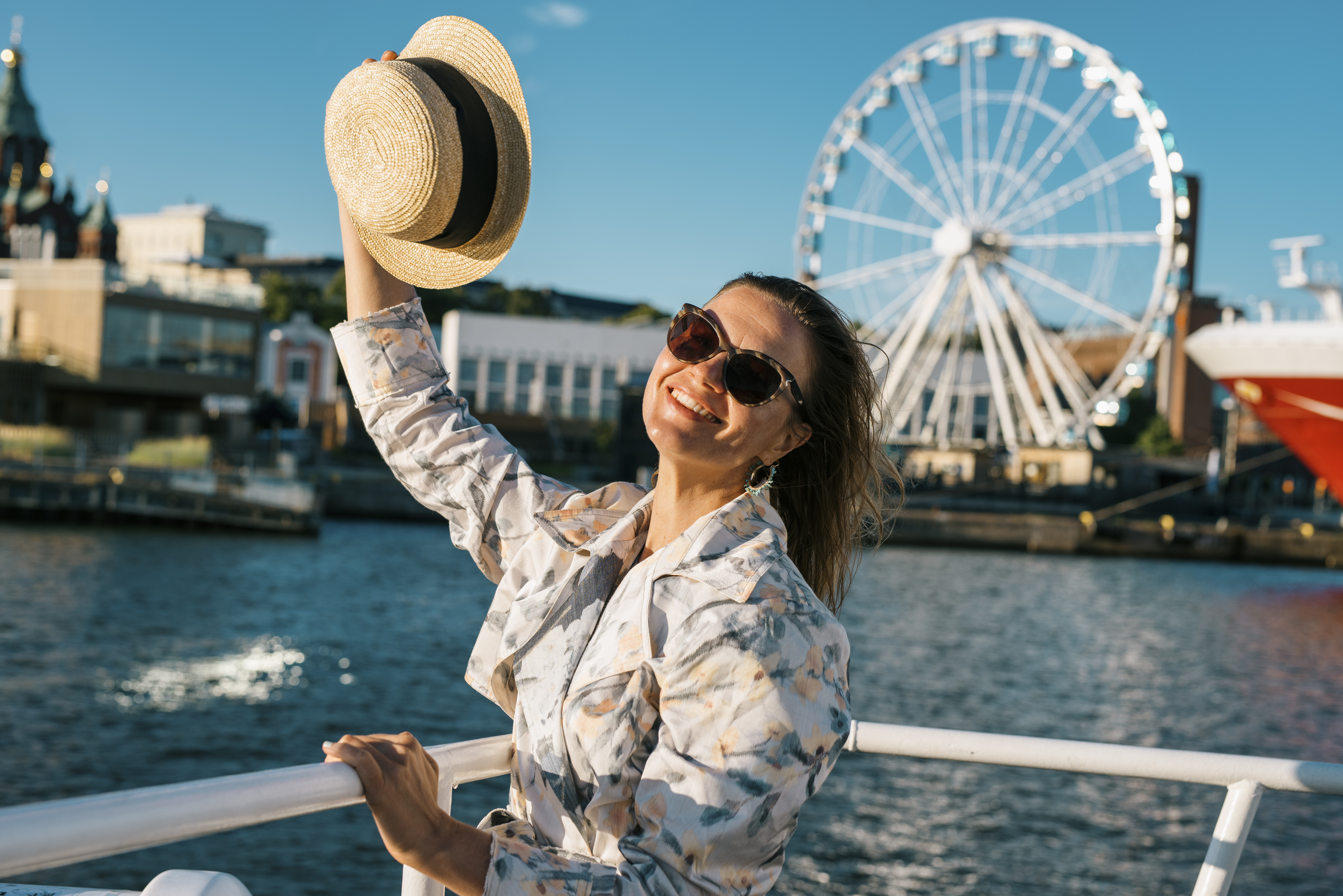 Une femme agitant son chapeau sur une rive d’Helsinki