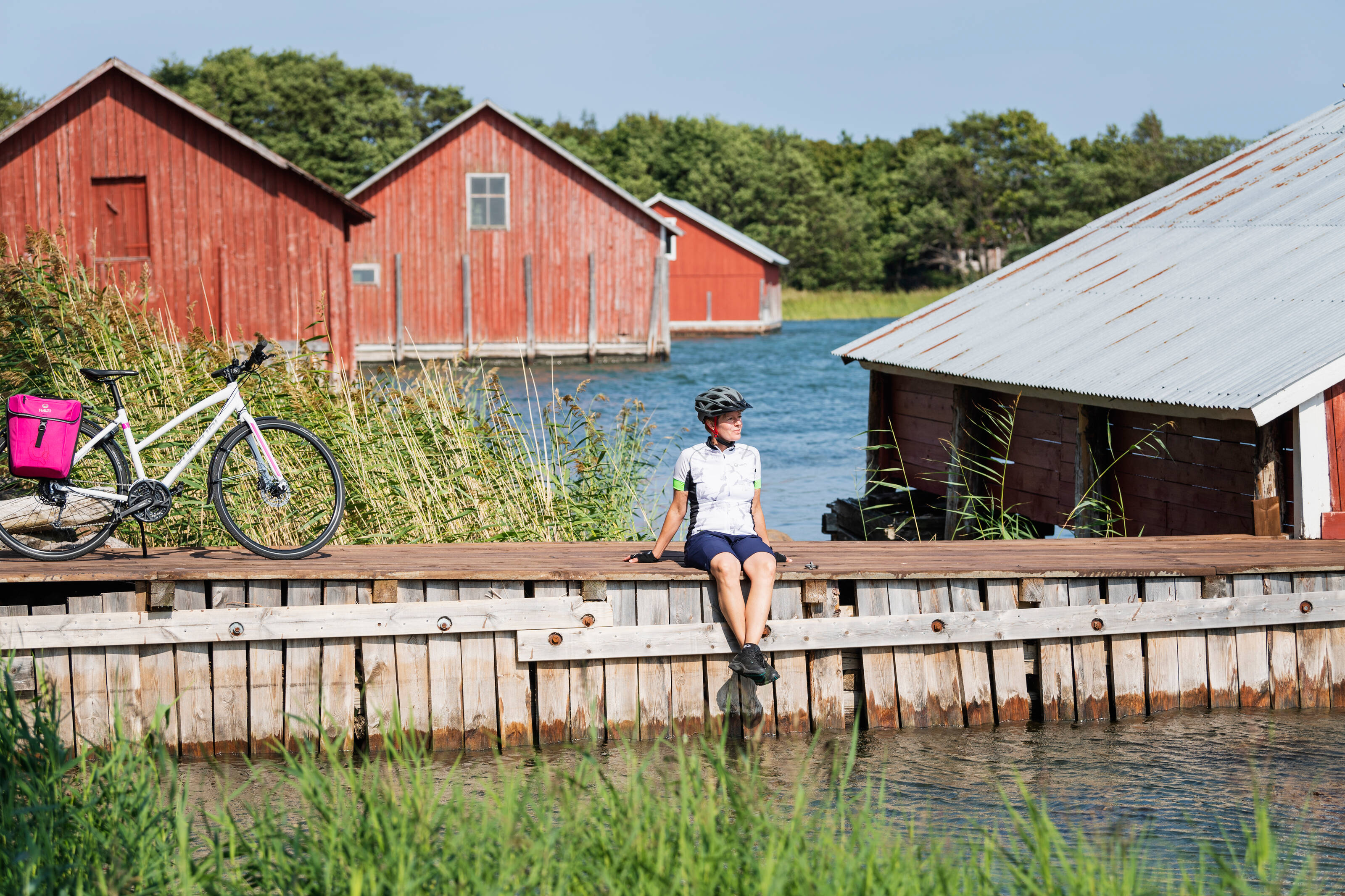 a cyclists on a break in an idyllic wooden village in the Finnish Archipelago