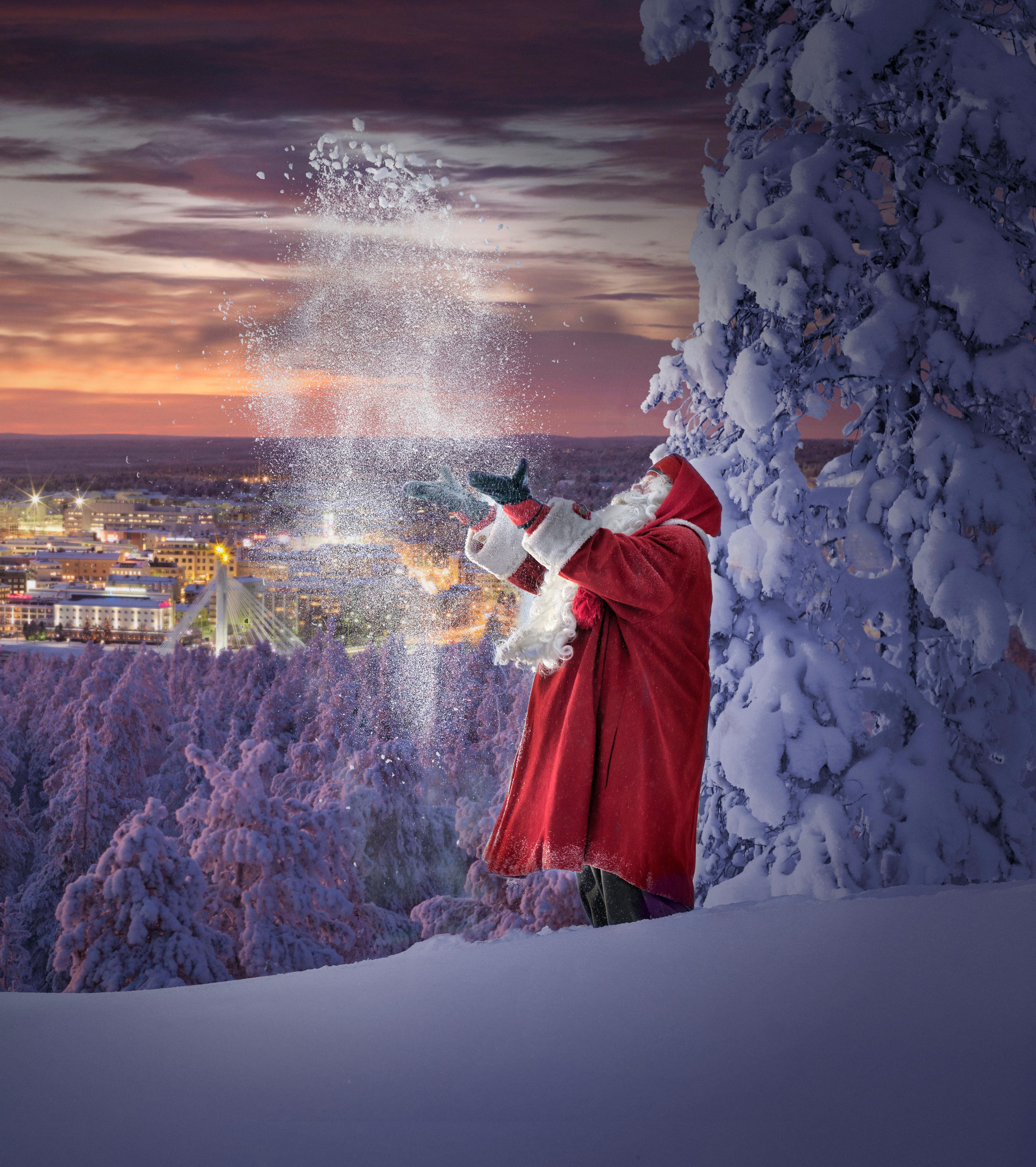 Santa throws snow in the air in front of the city of Rovaniemi