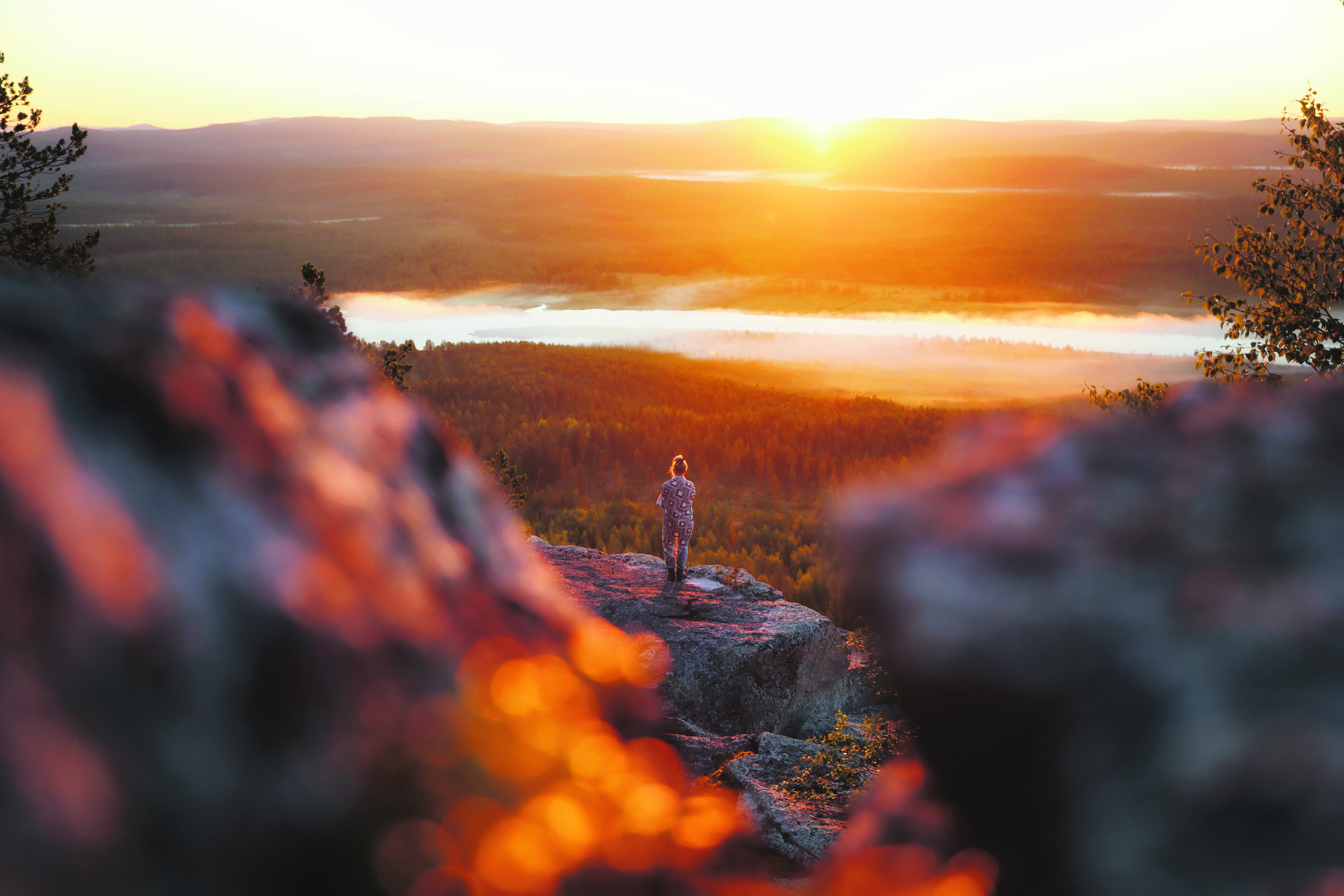 Une femme se tient au sommet d’une colline et regarde l’horizon