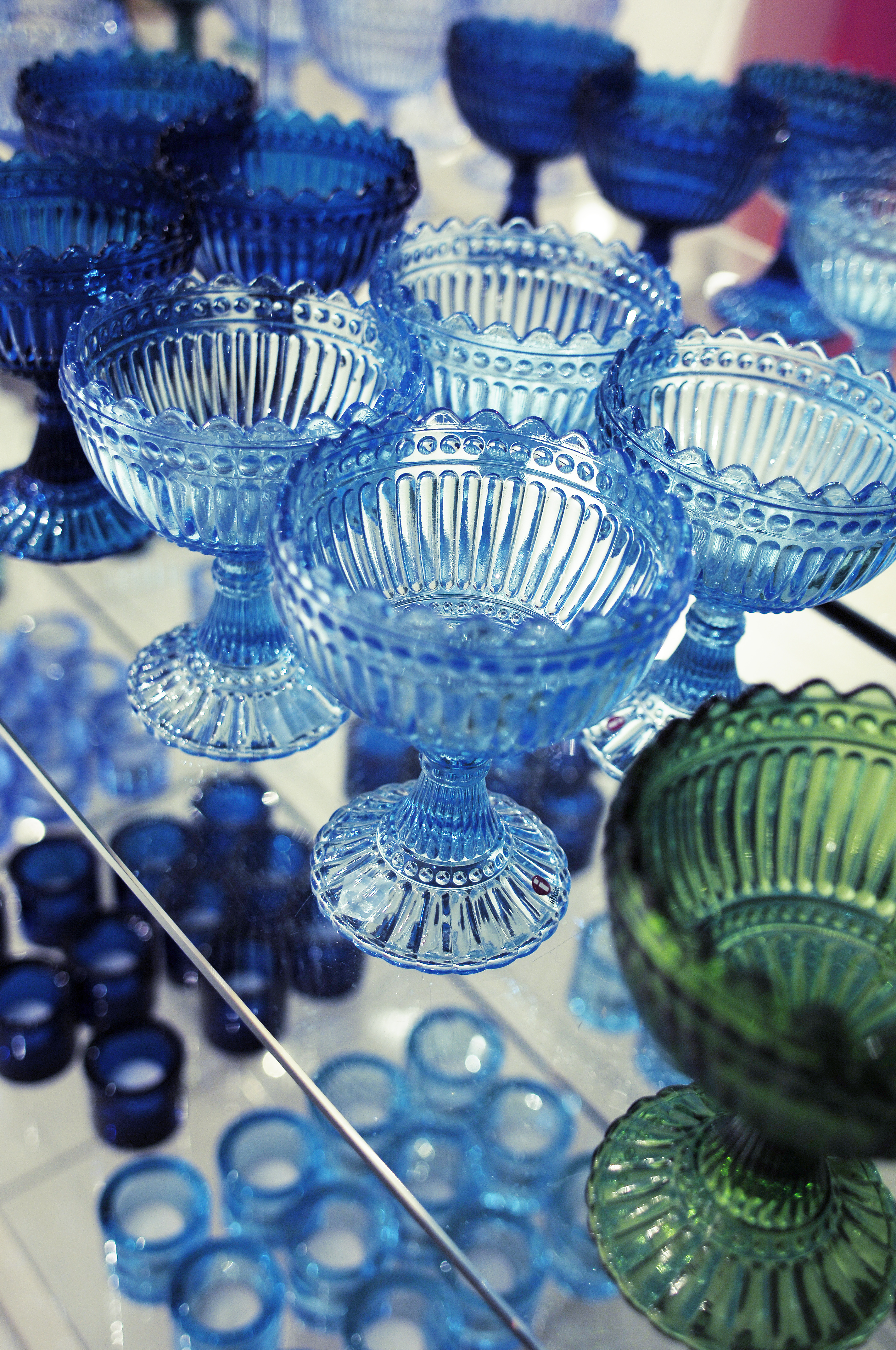 Dozen differently coloured Mariskooli bowls on a display.