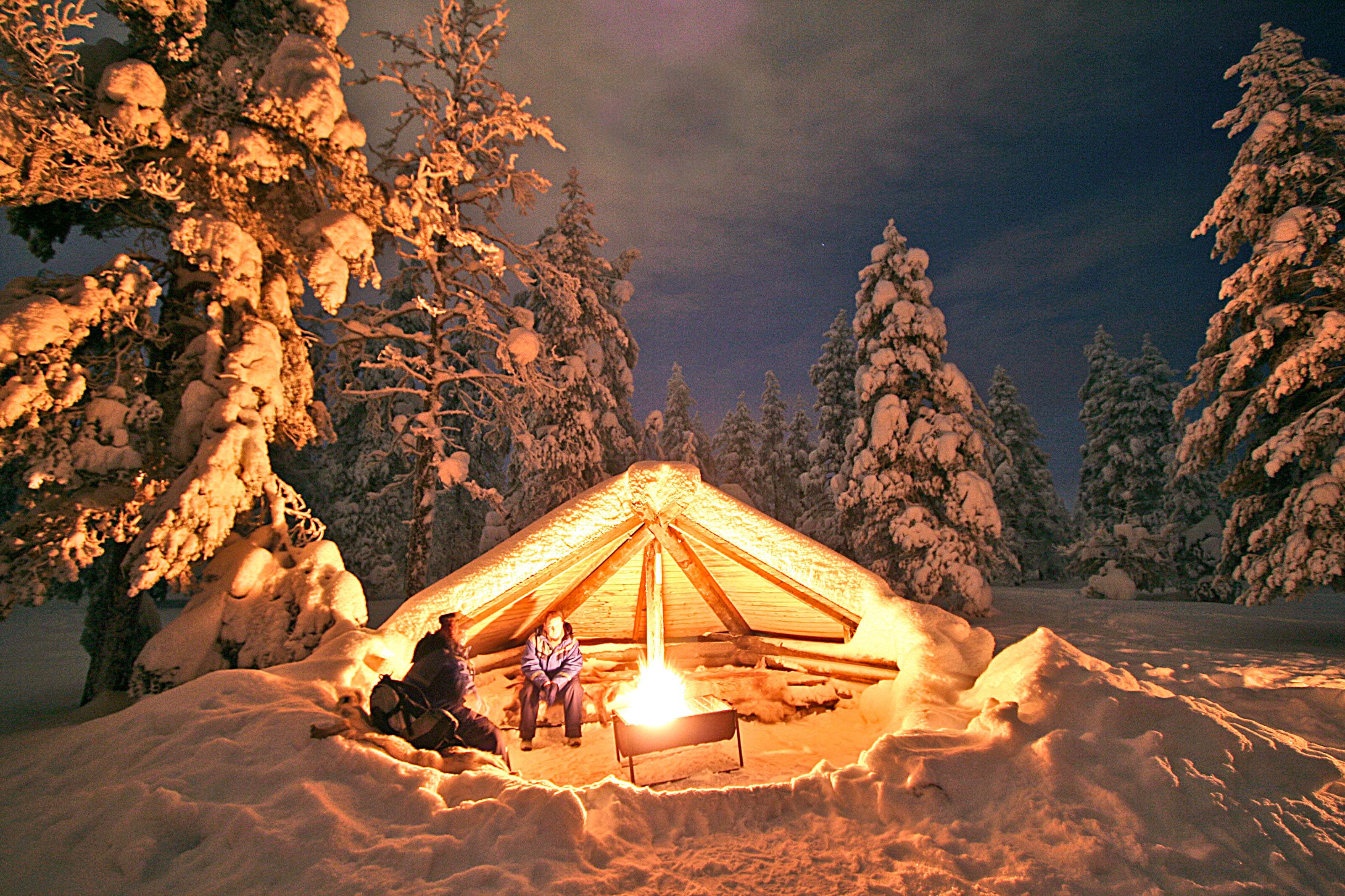 people warming up in a snowy camp