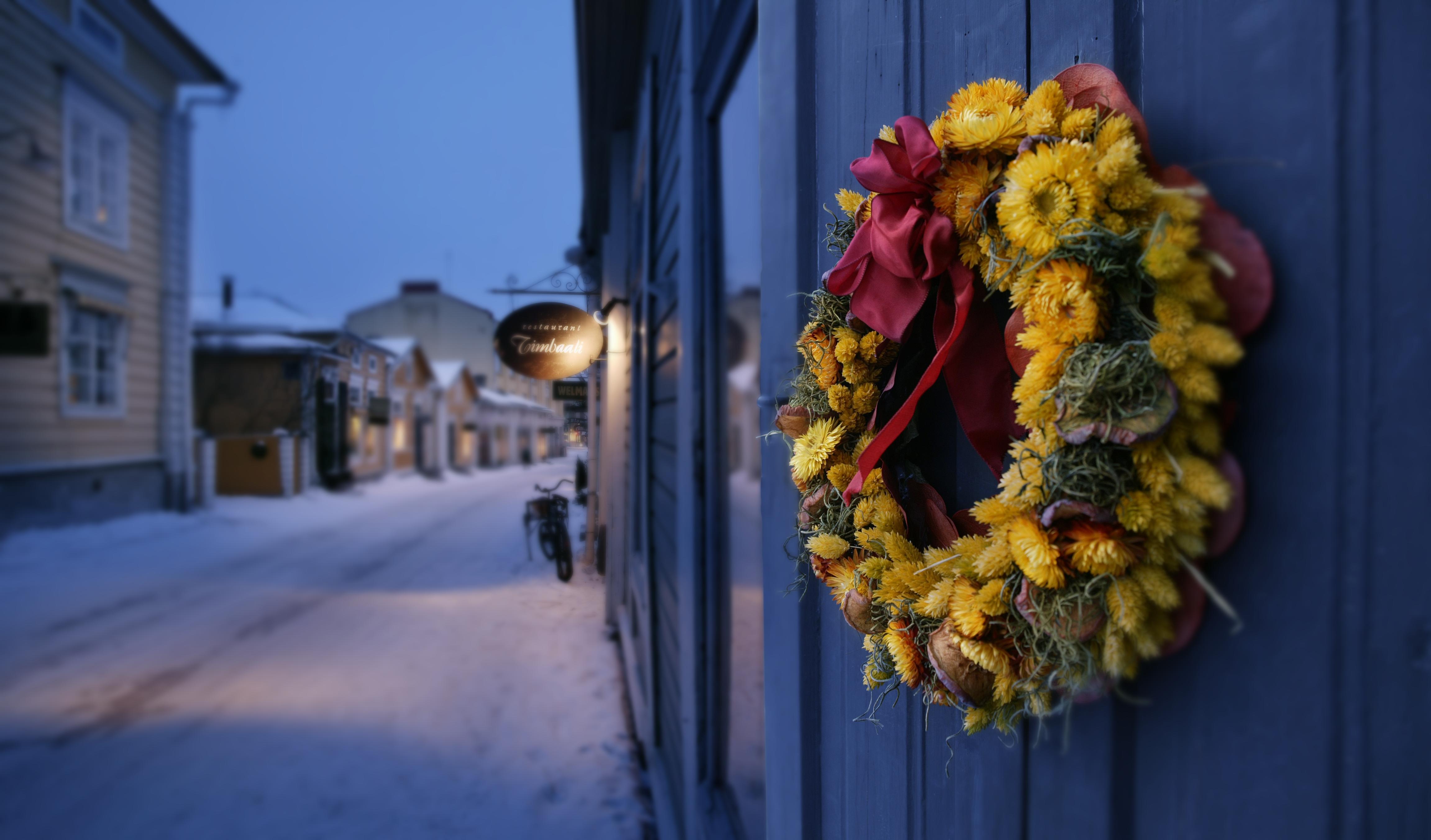 Une couronne de Noël sur un mur en bois dans une rue idyllique couverte de neige à Porvoo, Finlande
