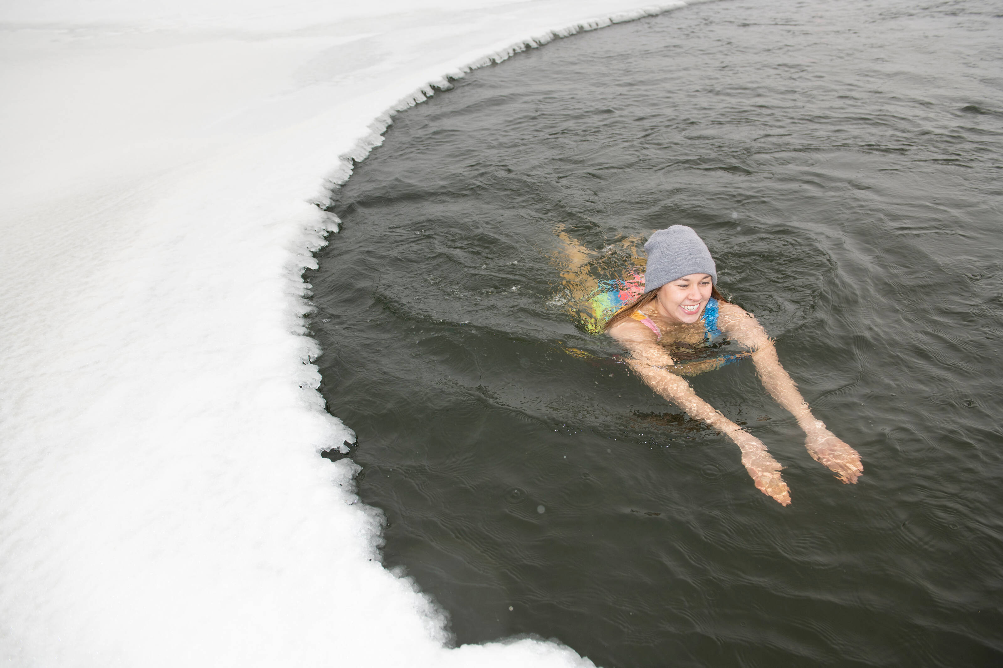 улыбающаяся женщина купается в ледяной воде