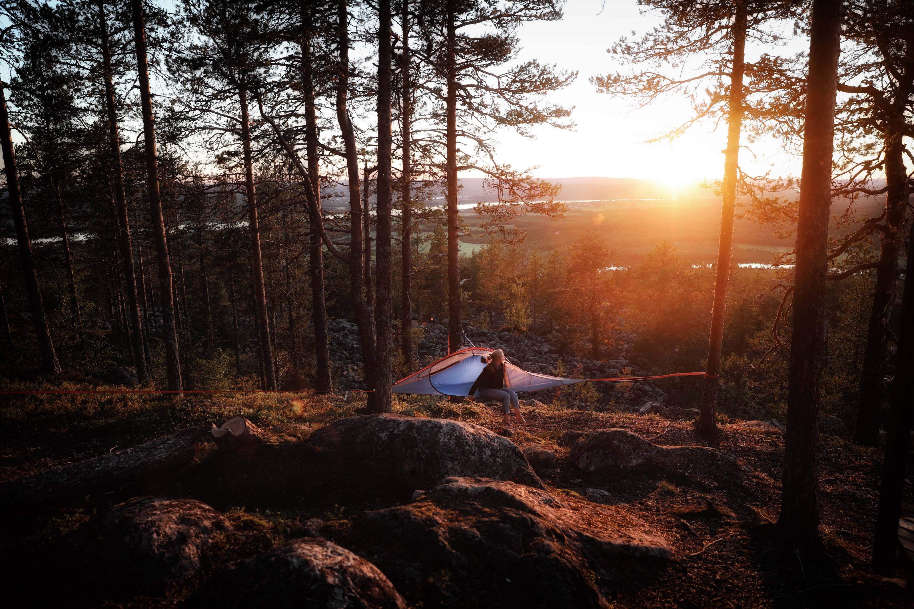 a woman tentsile camping in the breathtaking Finnish Lapland