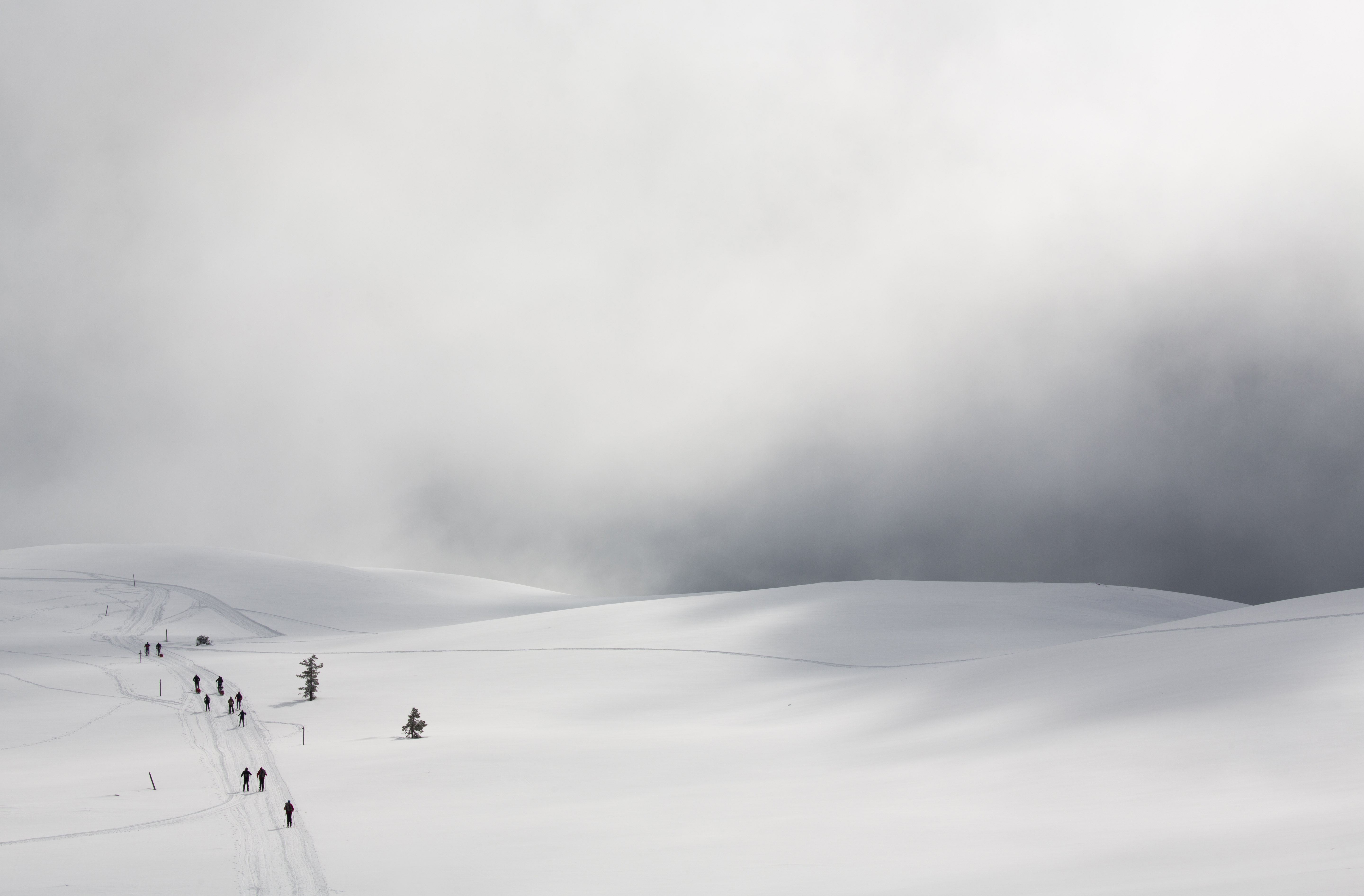 Skifahrer auf dem Gipfel eines Fjells, umgeben von Wolken