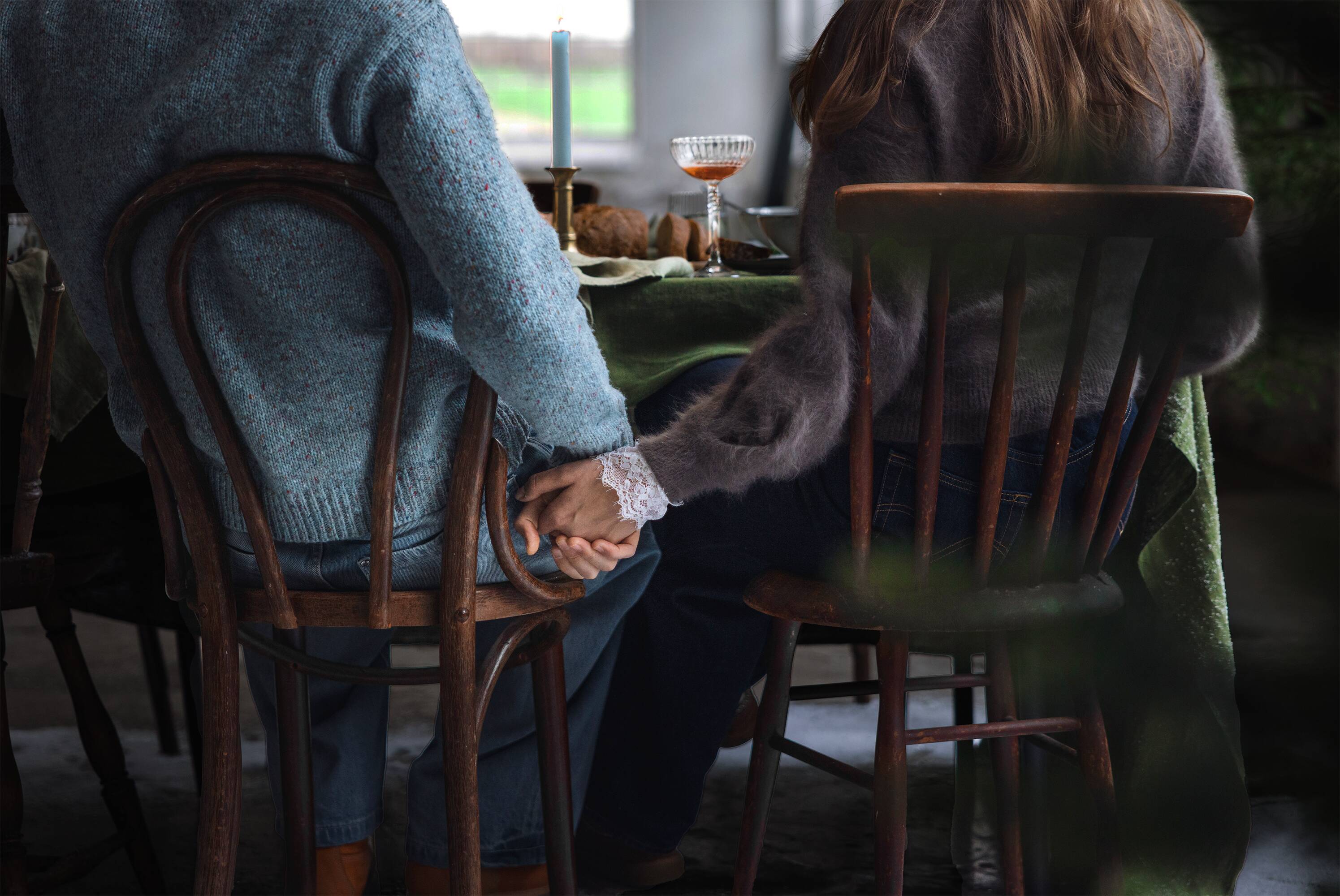 Finnish Dinner Date campaign hero image with a dinner table and two people holding hands.