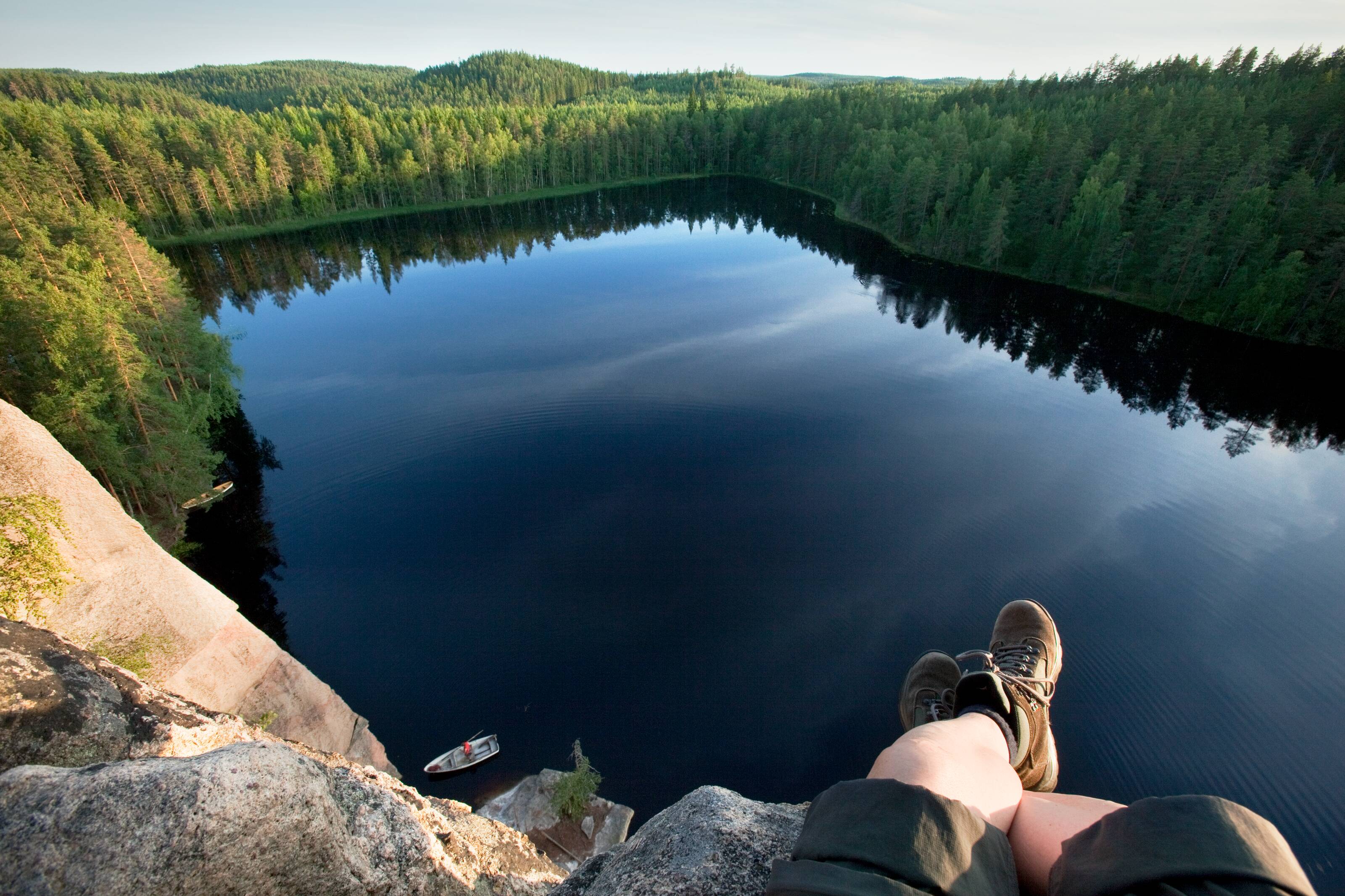 Landschaftsbild mit Blick auf einen rechteckigen See in einem Wald