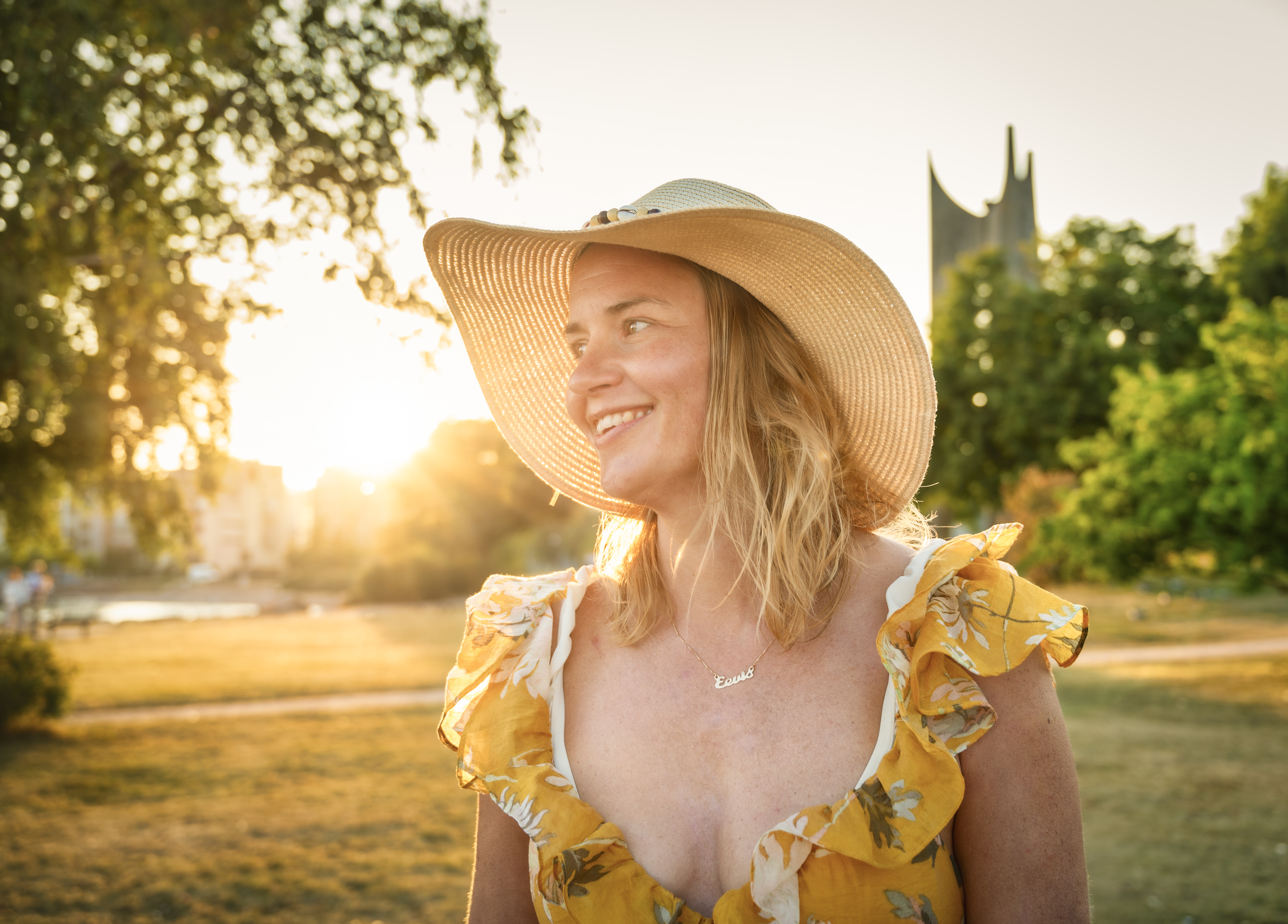 A woman wearing a summer dress smiling under the Midnight Sun