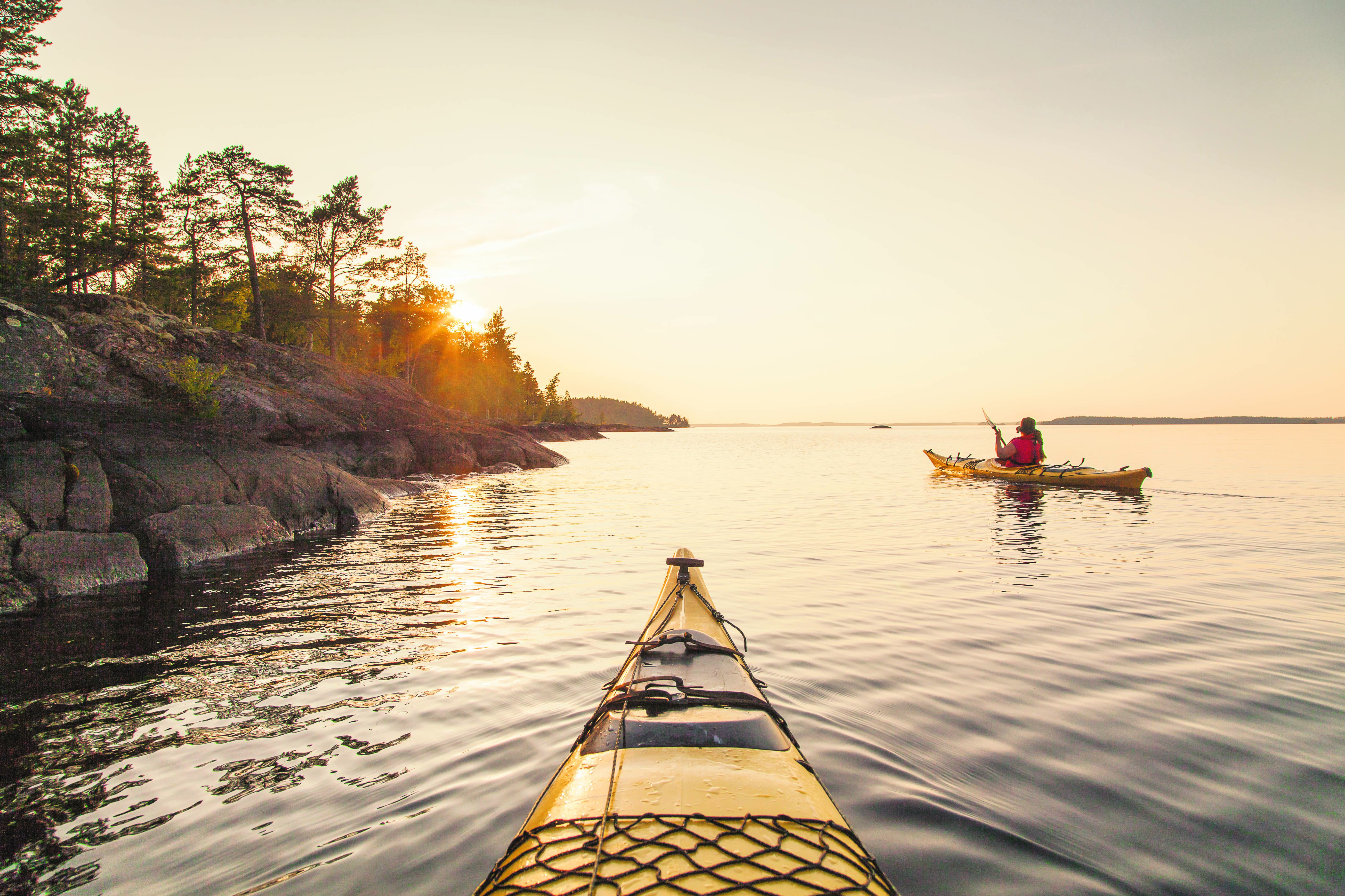Des personnes font du kayak dans la région des lacs au coucher du soleil