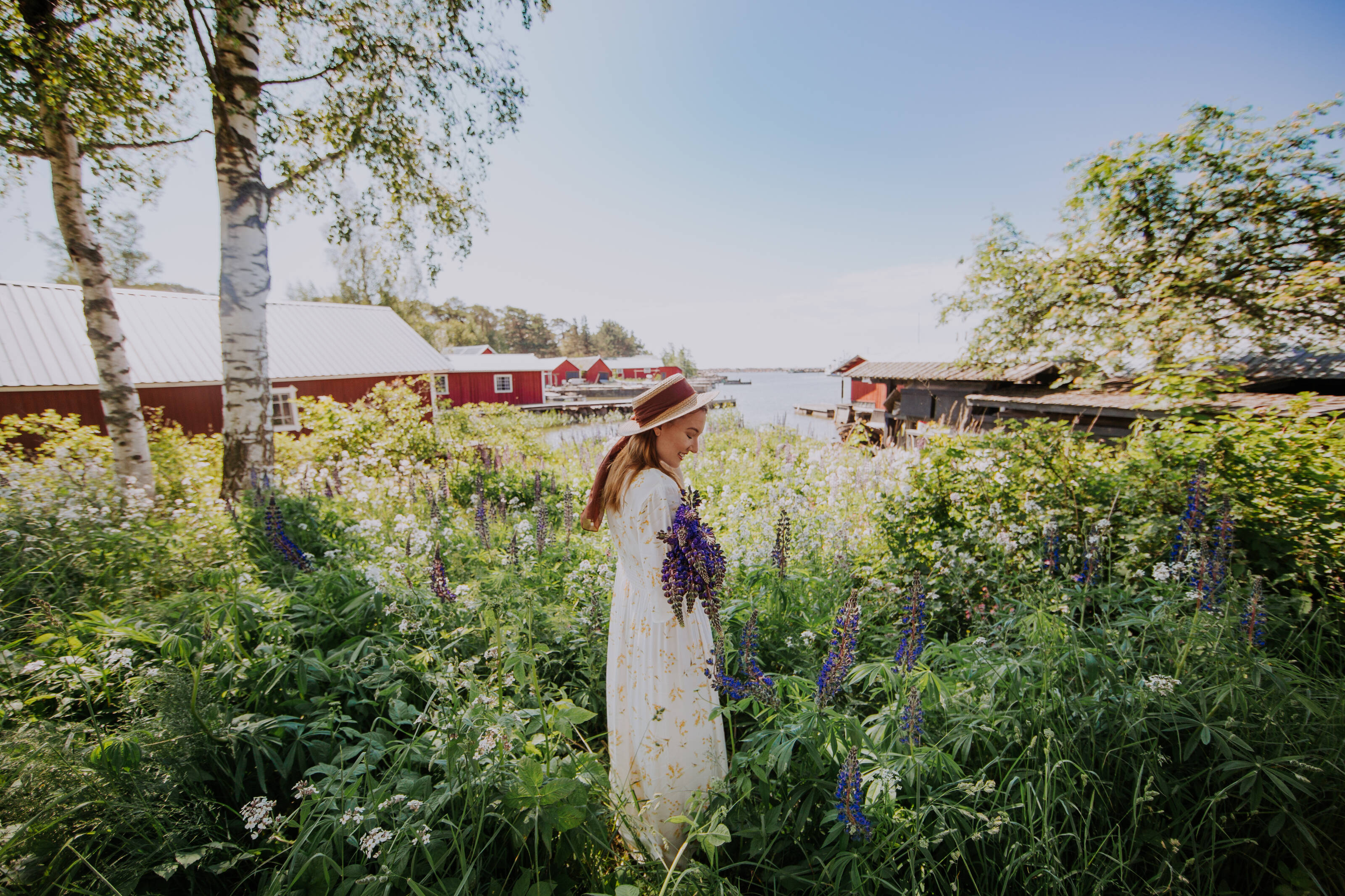 フィンランドのバルト海海岸に広がるのどかな浜辺の風景の中で淡褐色の花を持つ若い女性