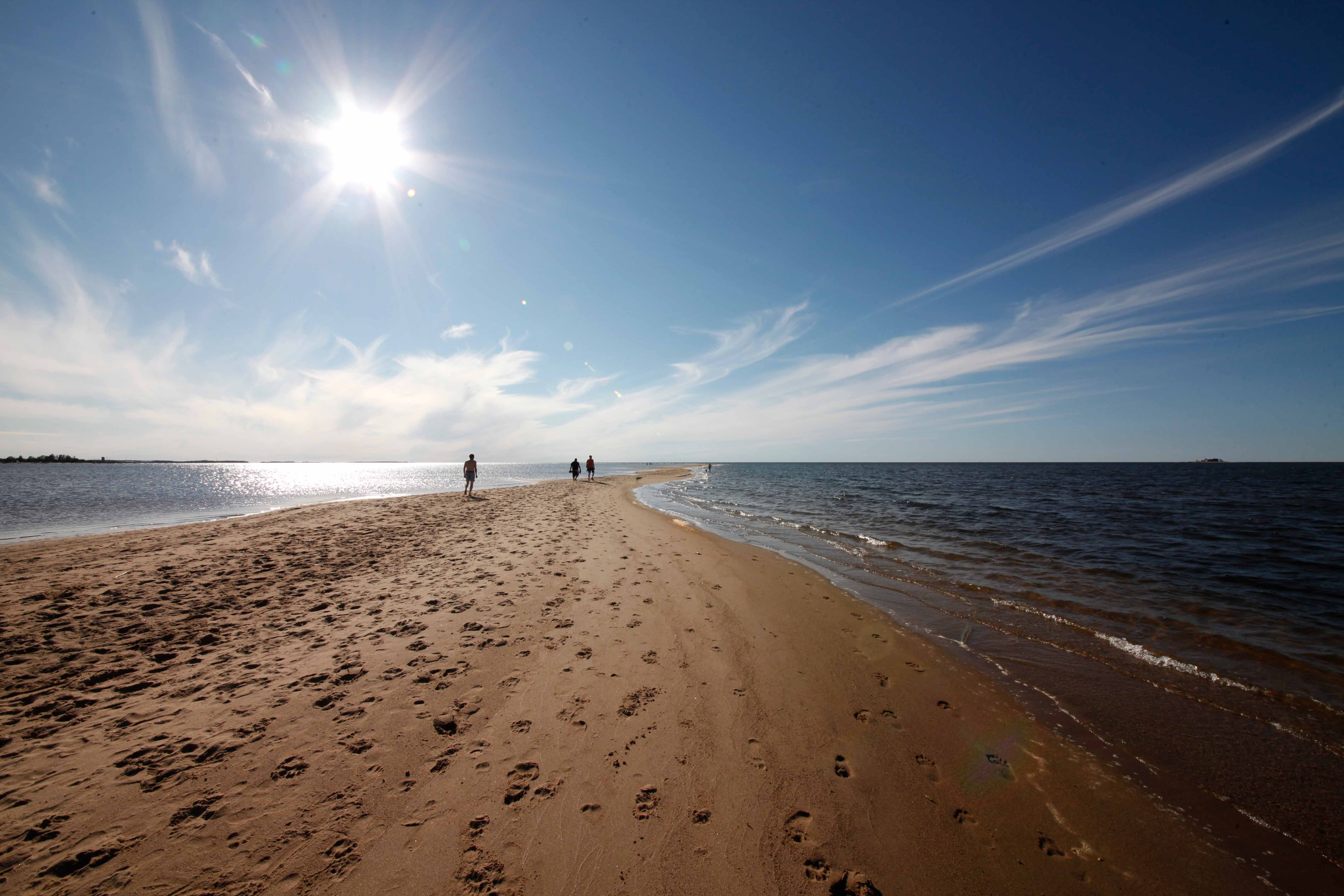 people walking in a sandy beach in the Finnish Coast