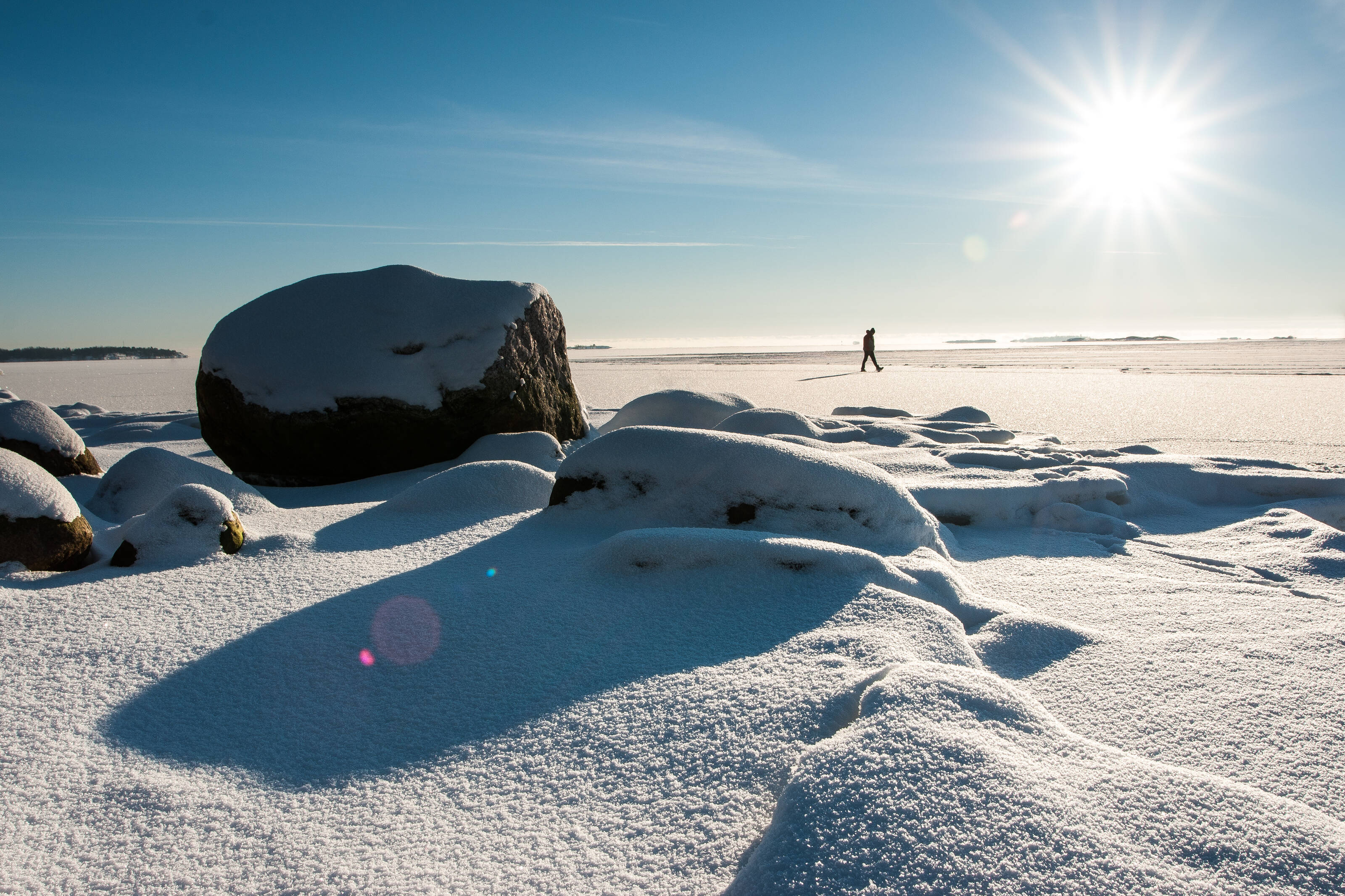 человек идет по льду Балтийского моря на архипелаге у Хельсинки