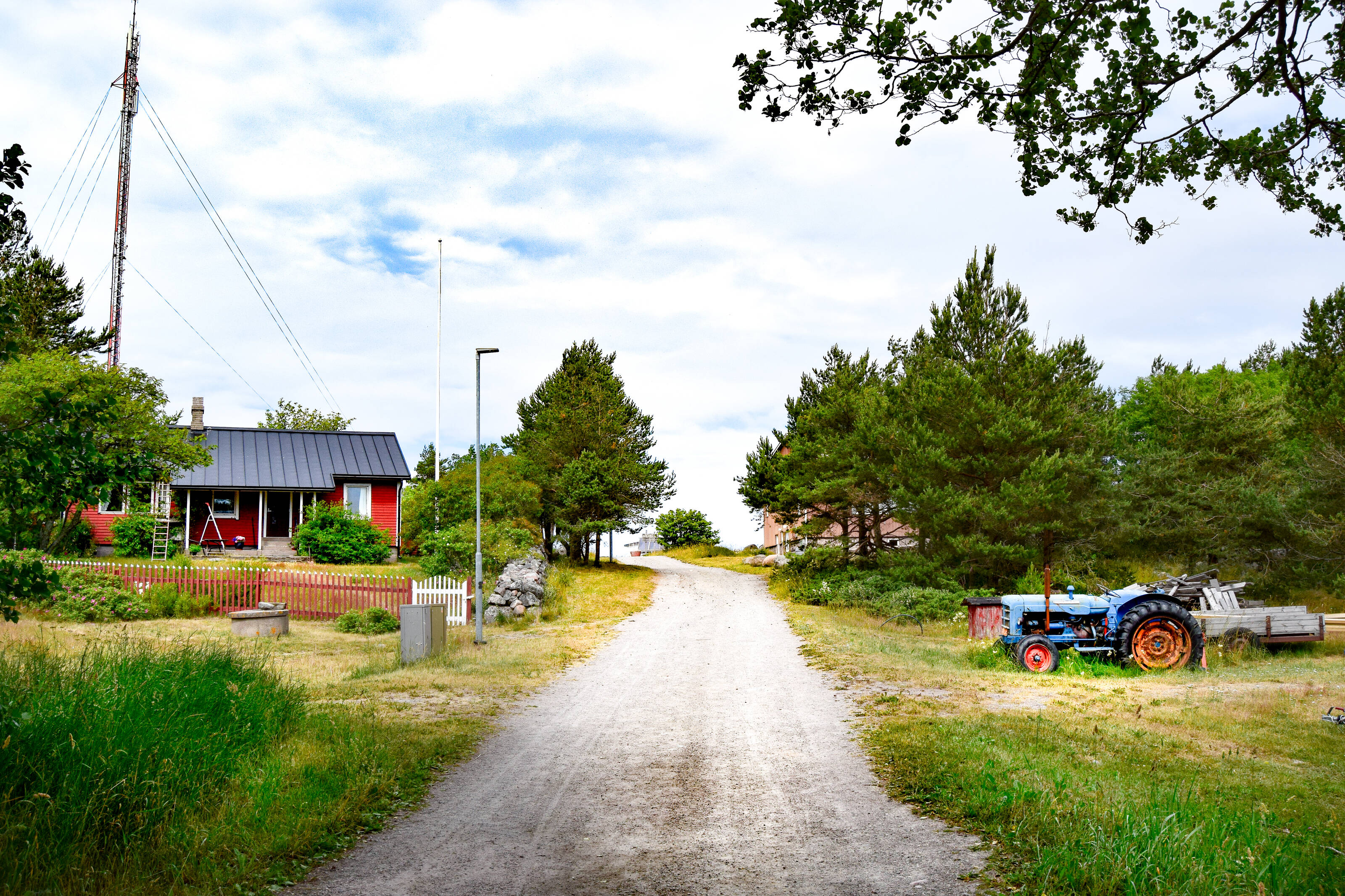 a gravel road crossing an idyllic village in the Finnish Archipelago