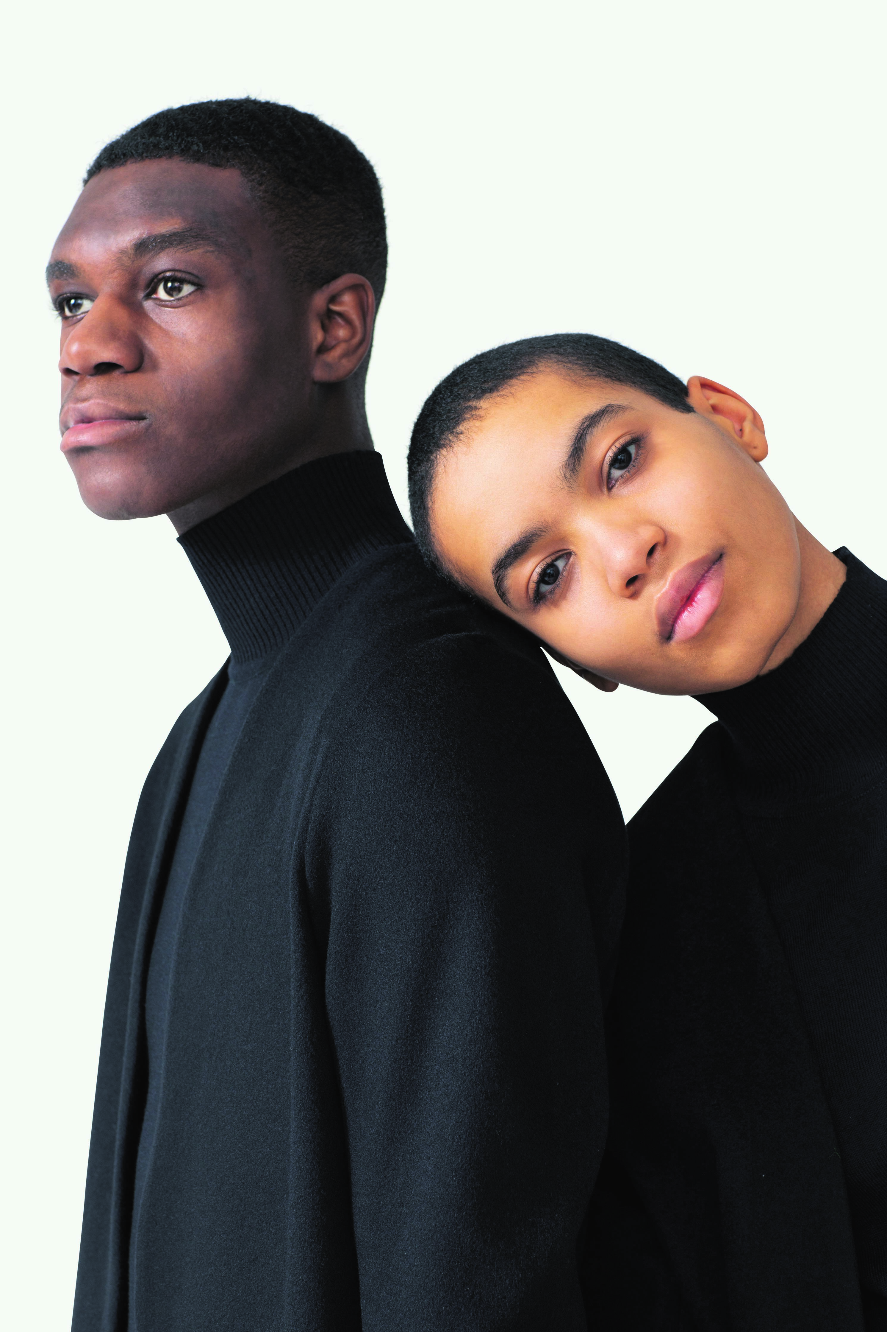 Two models wearing black unisex fashion clothes.